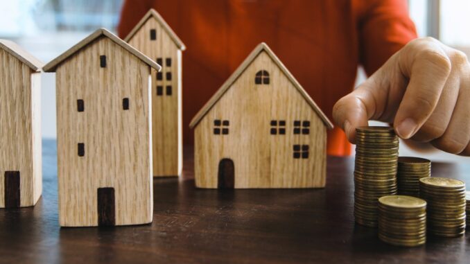 Investir en SCPI 2026 : maquettes immobilières et pièces de monnaie symbolisant le placement collectif
