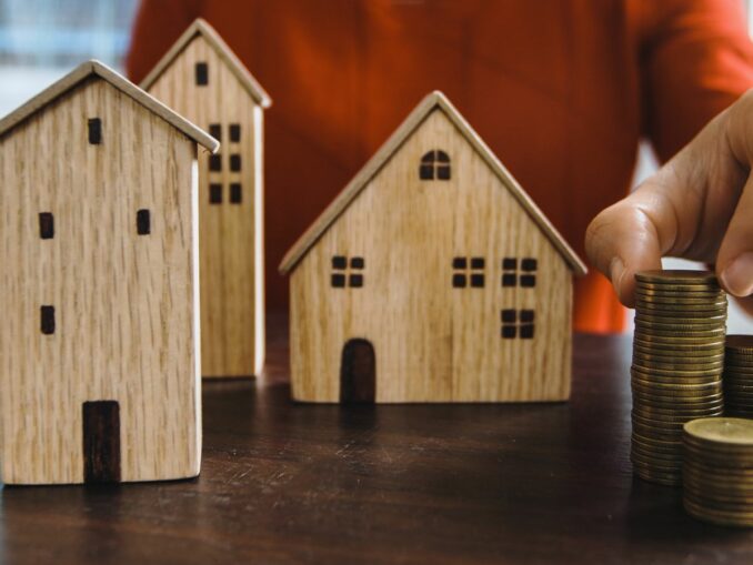 Investir en SCPI 2026 : maquettes immobilières et pièces de monnaie symbolisant le placement collectif