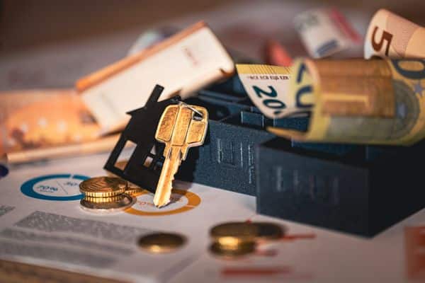 Clé de maison, billets euros et graphiques financiers illustrant le PLF 2027 et la fiscalité immobilière
